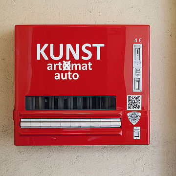 Roter Kunstautomat mit Kunstwerken verschiender Künstler*innen