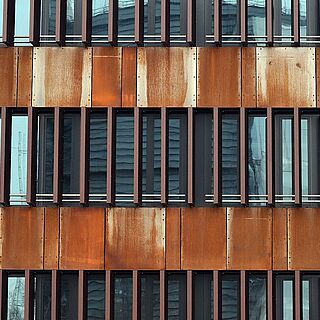 Fensterfassade eines Gebäudes auf dem Gaswerksgelände. In der Reflektion sieht man den Gaskessel. Weiterverlinkung auf Gaswerk Künstlerverzeichnis Seite