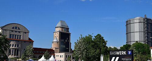 Blick auf das Gaswerksgelände, auf dem junge Menschen zu einer Veranstaltung strömen.