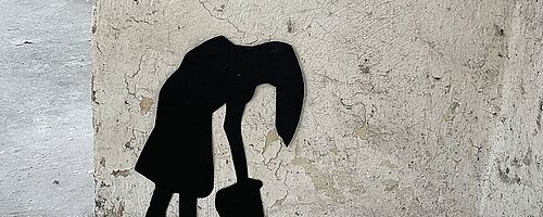 Schattenfigur an einer Steinwand. Weiterverlinkung auf Kunstausstellung Newsartikel