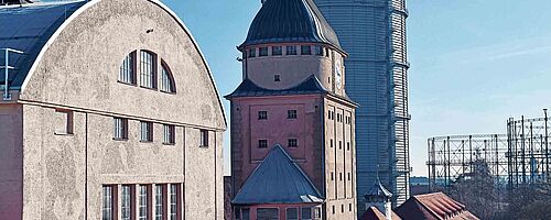 Außenansicht von Gebäuden und dem Gasbehälter auf dem Gaswerk. Weiterverlinkung auf "Das Gaswerk ist ein phantastischer Ort" Newsartikel