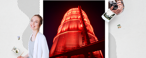 rot beleuchtetes Gaswerk in Bilderrahmen. Außerhalb des Rahmens sind zwei Personen mit Kamera und Pinsel in der Hand. Weiterverlinkung auf ARTram Newsartikel